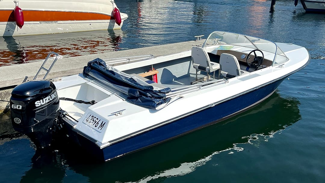 Sportliches Motorboot mit 60-PS-Suzuki-Außenborder, Windschutzscheibe und Sportsitzen im Stadthafen Waren an der Müritz.