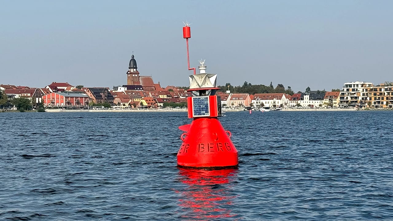 Blick vom Wasser auf die Stadt Waren an der Müritz mit Kirchturm und Hafenpromenade.